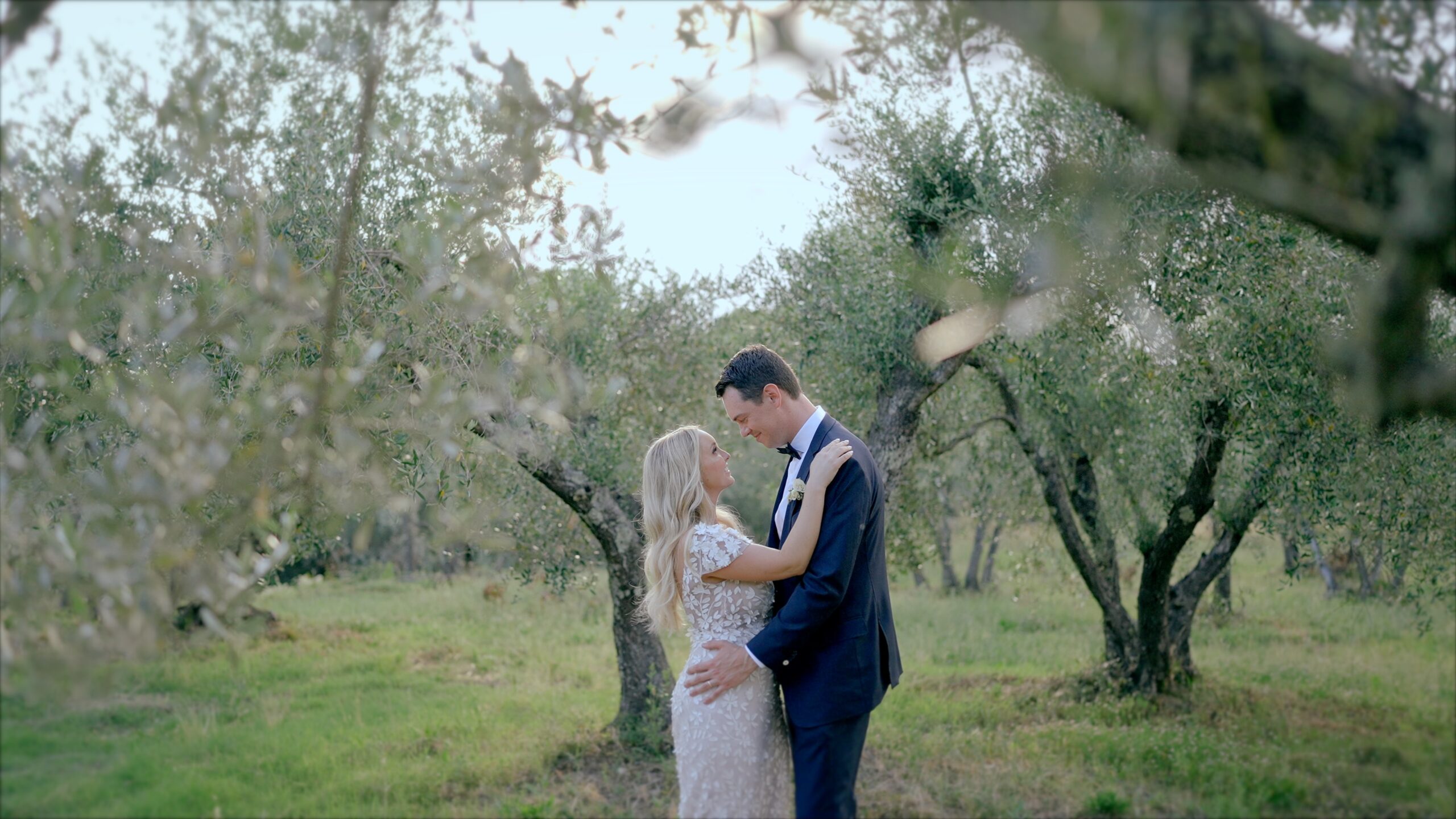 Bride and groom embracing among olive trees in the countryside during their wedding day