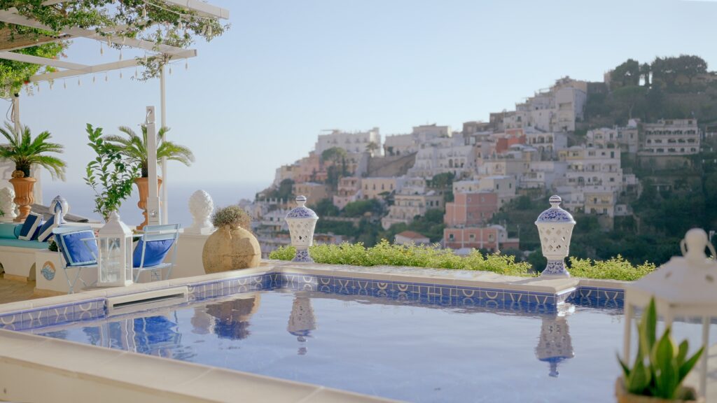 Luxury terrace with blue pool, ceramic decorations and panoramic view of Positano on the Amalfi Coast.