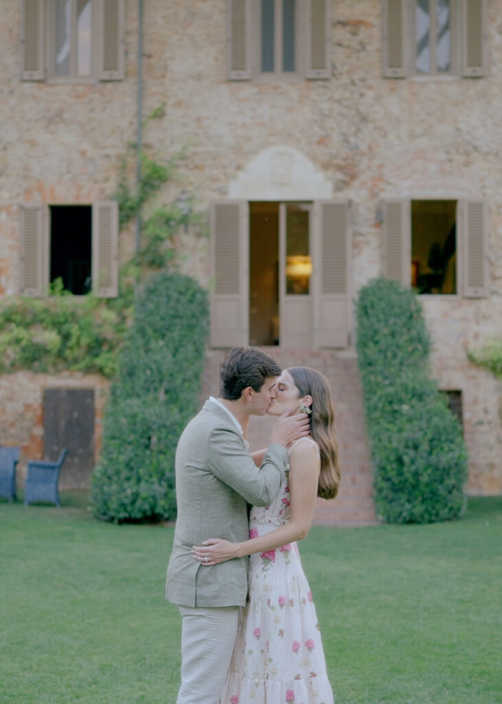 Couple kissing in front of a historic Italian villa during an intimate countryside elopement in Italy.
