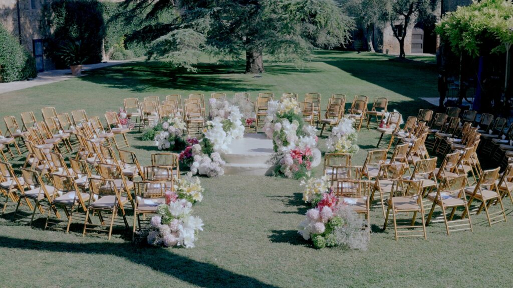 Luxury garden wedding ceremony at La Pescaia Resort with floral decorations and elegant seating in Tuscany.