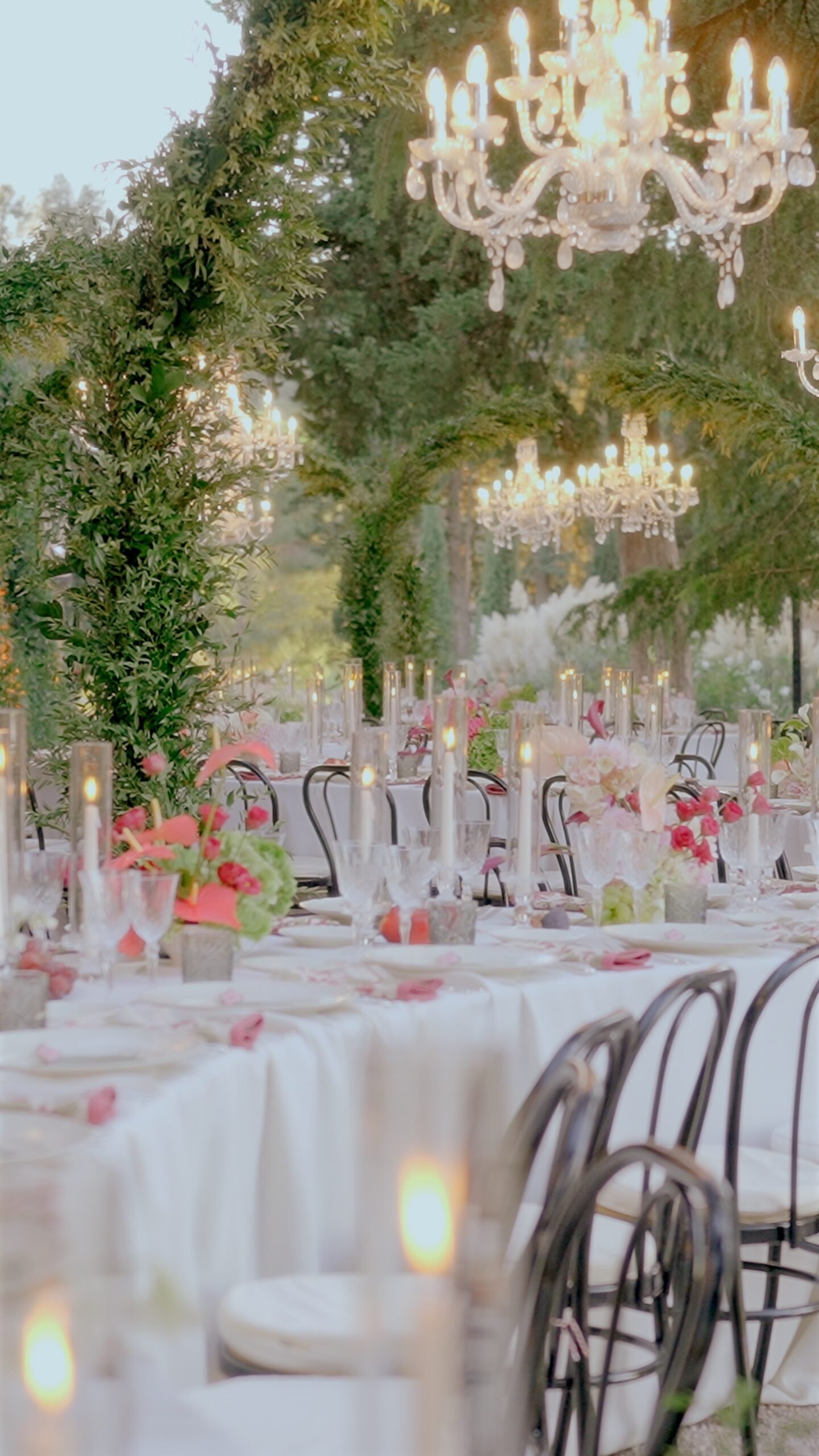 Elegant outdoor wedding dinner at La Pescaia Resort in Tuscany with chandeliers, candles and floral decor.