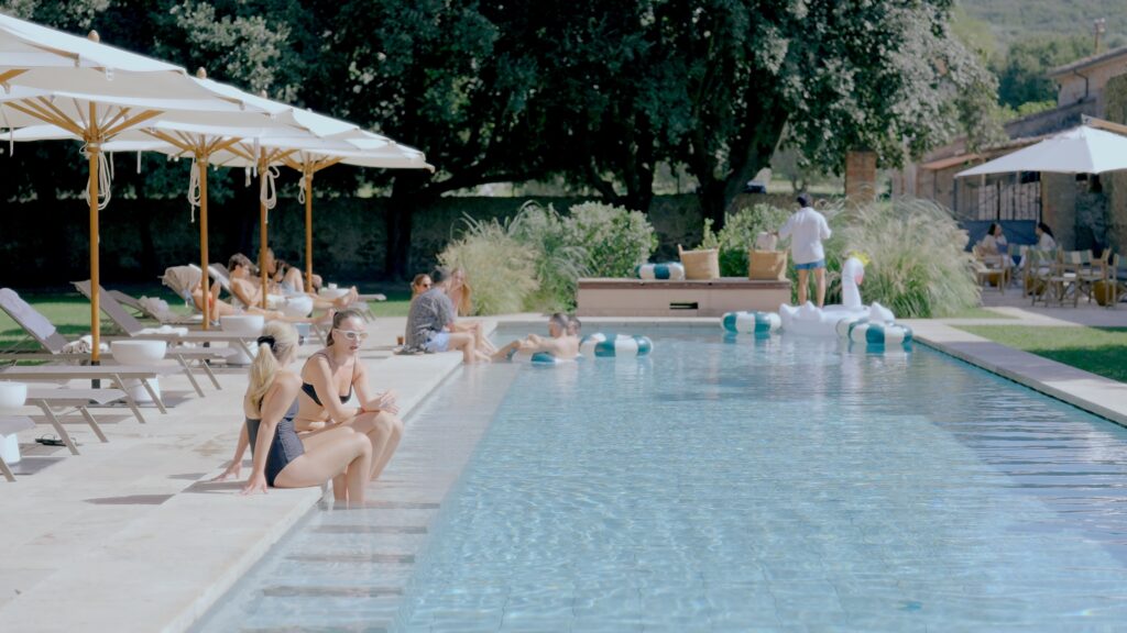 Guests relaxing by the pool at La Pescaia Resort during a destination wedding weekend in Tuscany.