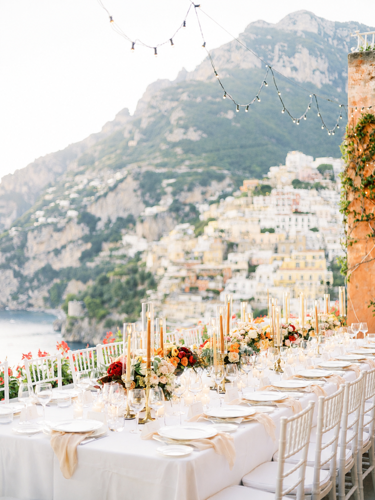 Amalfi Coast Wedding Videographer 4 Luxury Amalfi Coast wedding reception with elegant candlelit table overlooking Positano and the Mediterranean coastline at sunset.