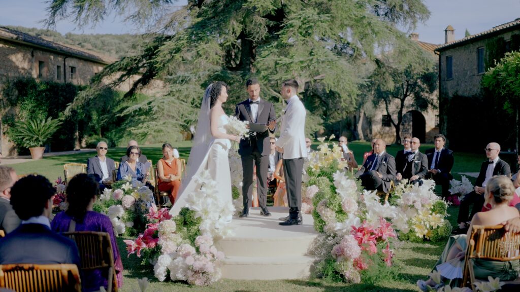 Luxury outdoor wedding ceremony at La Pescaia Resort in Tuscany with floral arrangements, garden setting and elegant destination wedding atmosphere.