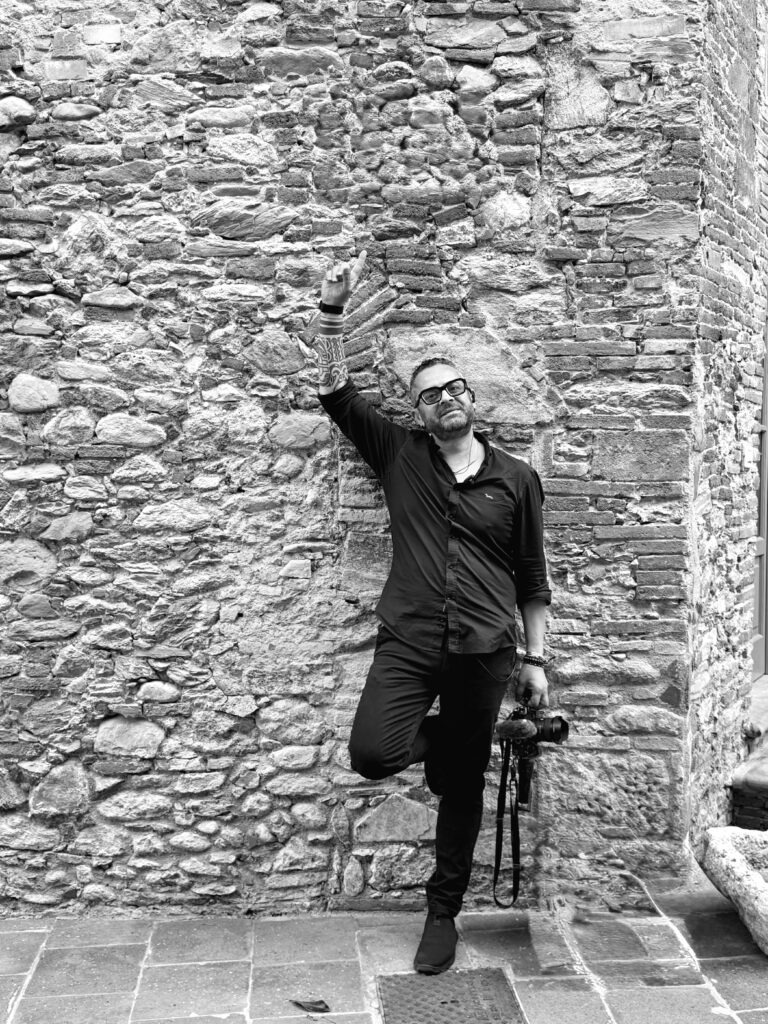 Luxury destination wedding videographer in Italy portrayed in a cinematic black and white editorial portrait.