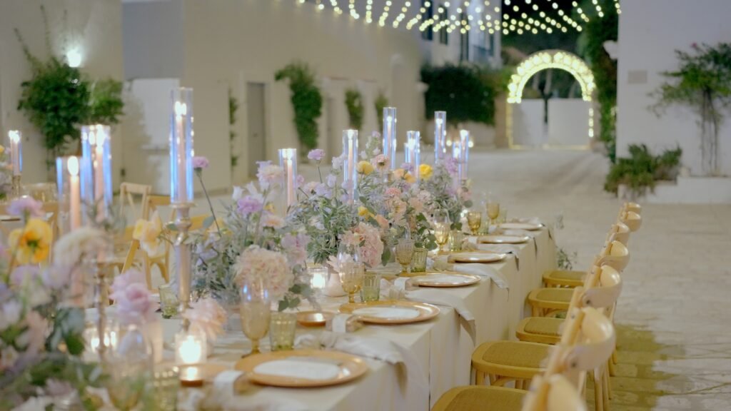 Elegant outdoor wedding reception in Puglia with pastel flowers, candles and illuminated courtyard